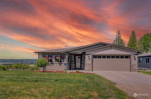 ranch-style house featuring a garage and a yard