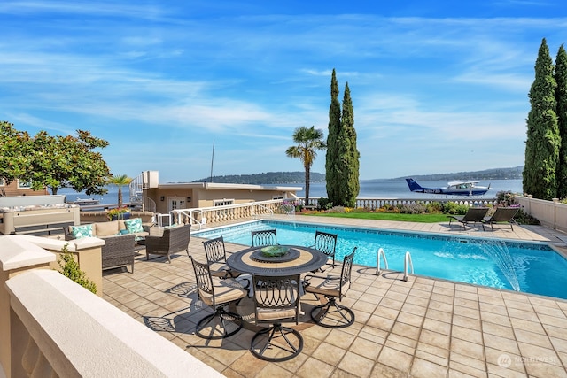 view of swimming pool with a patio area and a water view