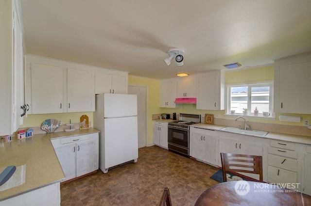 kitchen with white cabinets, sink, white fridge, and range