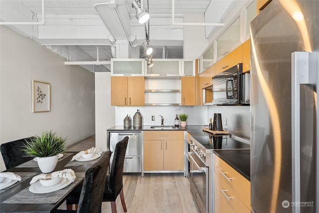 kitchen with light brown cabinetry, sink, appliances with stainless steel finishes, and light hardwood / wood-style flooring