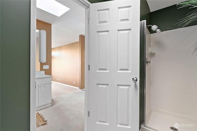 hall featuring light carpet and a skylight