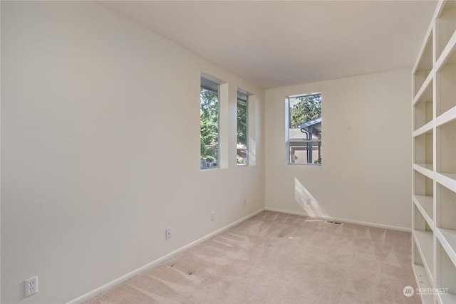 unfurnished room featuring light carpet