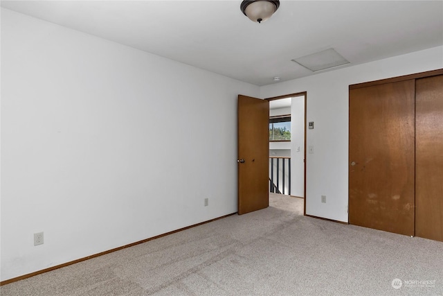 unfurnished bedroom with light colored carpet and a closet