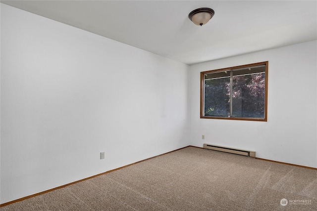 spare room with carpet and a baseboard heating unit