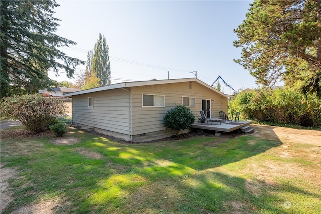 rear view of property with a deck and a lawn