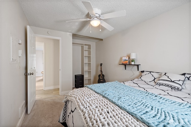 bedroom with a closet, a textured ceiling, ceiling fan, and carpet flooring