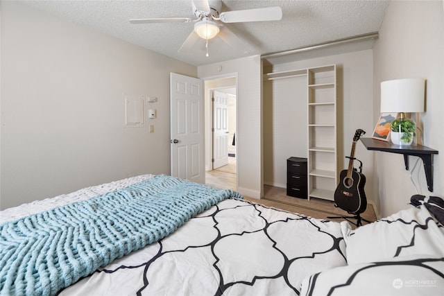 bedroom featuring a closet, a textured ceiling, ceiling fan, and light wood-type flooring