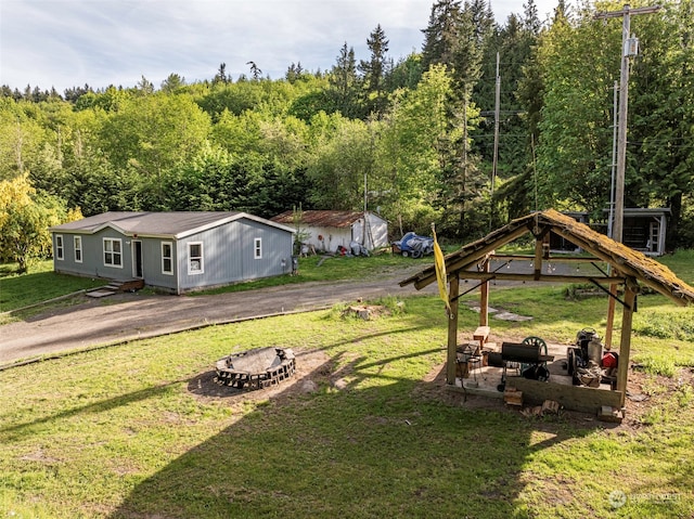 view of yard with a gazebo, a fire pit, and an outdoor structure