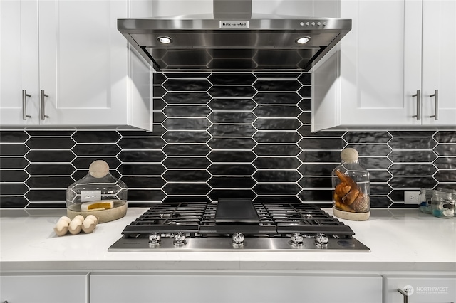 kitchen featuring ventilation hood, decorative backsplash, and white cabinets