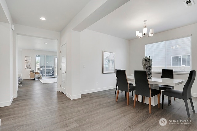 dining room featuring dark wood-type flooring and an inviting chandelier