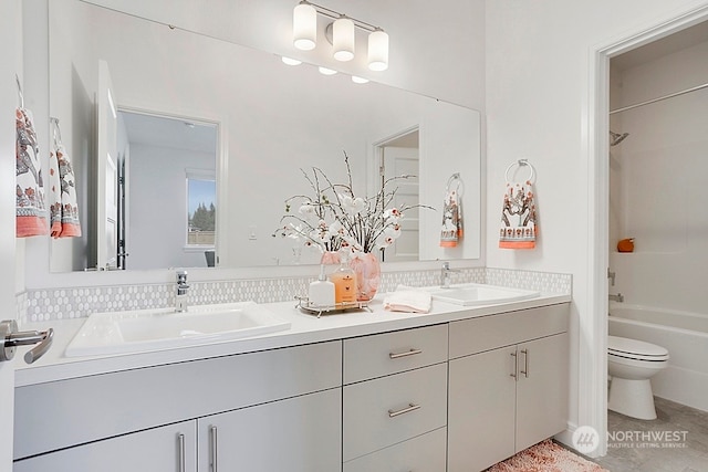 full bathroom featuring washtub / shower combination, vanity, and toilet