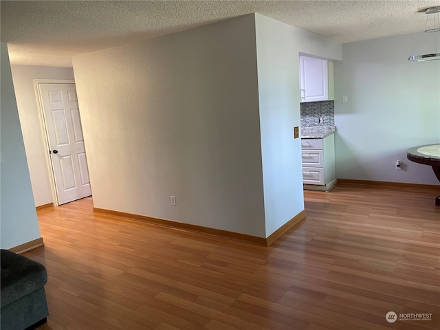 unfurnished room featuring light hardwood / wood-style floors and a textured ceiling