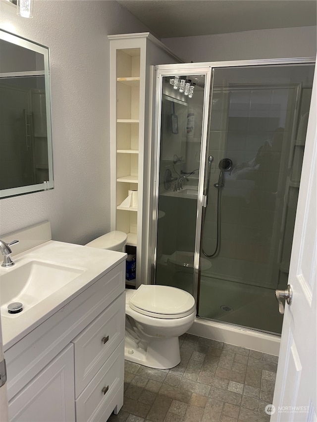 bathroom featuring tile flooring, an enclosed shower, toilet, and large vanity