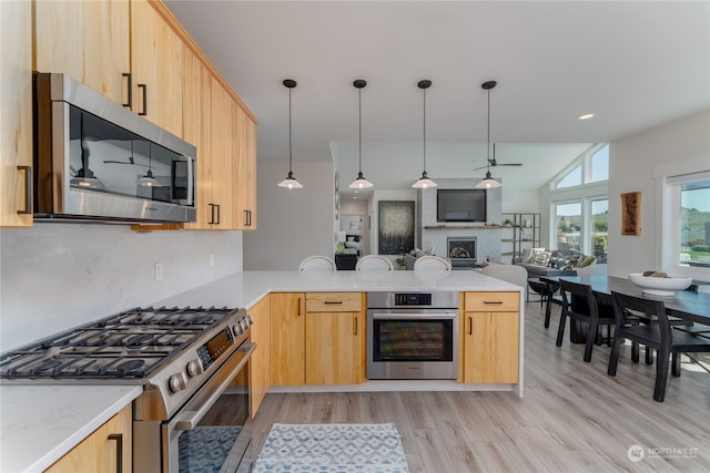 kitchen featuring appliances with stainless steel finishes, light hardwood / wood-style floors, kitchen peninsula, and light brown cabinets