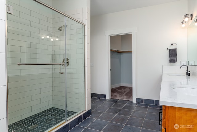 bathroom featuring tile floors, a shower with shower door, and double vanity