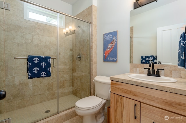 bathroom with walk in shower, tile floors, backsplash, large vanity, and toilet