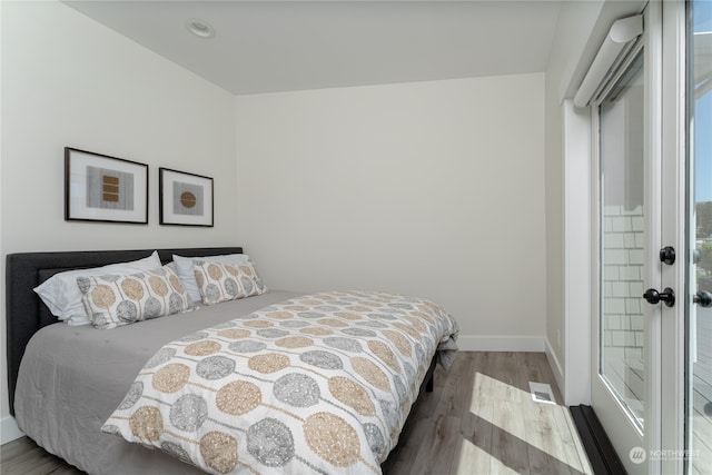 bedroom with french doors and wood-type flooring