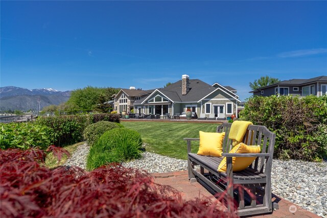 rear view of house featuring a lawn and a mountain view