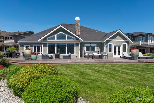 rear view of property with an outdoor hangout area, a lawn, and a deck