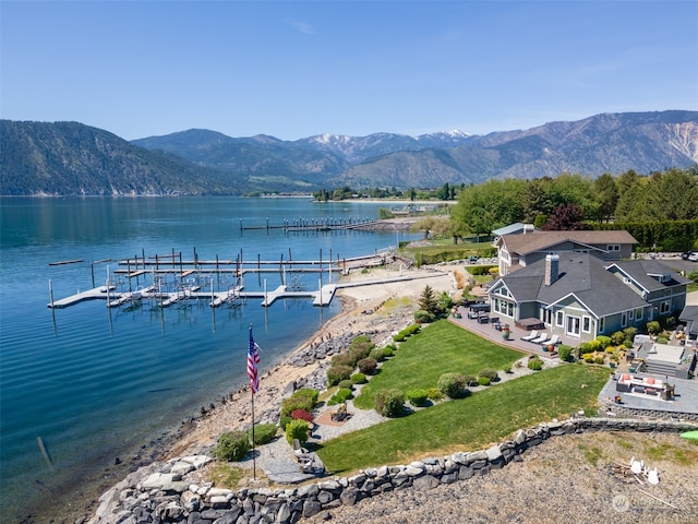 exterior space with a lawn and a water and mountain view