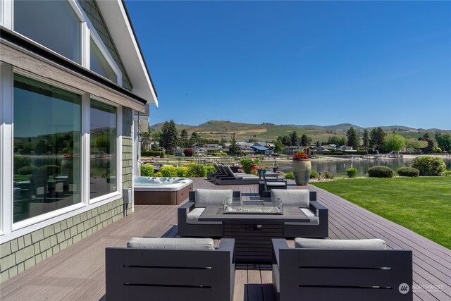 deck featuring a mountain view, a hot tub, and an outdoor hangout area