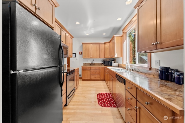 kitchen with stainless steel appliances, sink, and light hardwood / wood-style floors