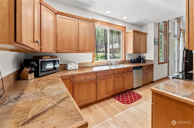 kitchen with sink, light wood-type flooring, and appliances with stainless steel finishes