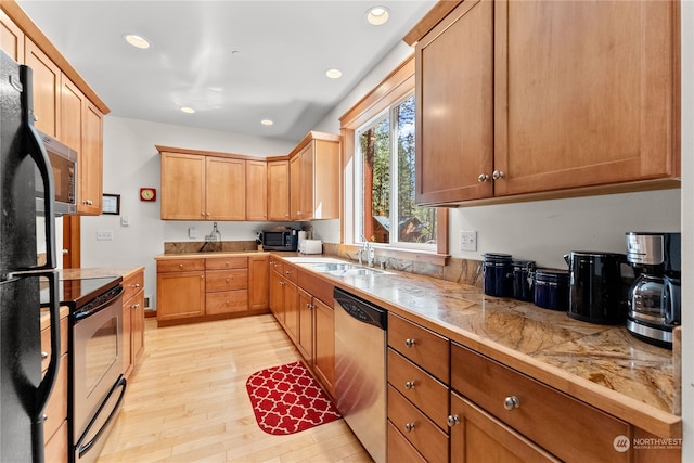 kitchen featuring stainless steel appliances, sink, and light hardwood / wood-style flooring