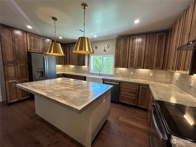 kitchen with a center island, hanging light fixtures, dark hardwood / wood-style flooring, appliances with stainless steel finishes, and tasteful backsplash