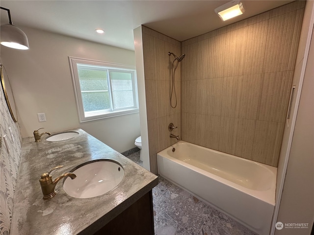 full bathroom featuring tiled shower / bath, toilet, tile floors, and double vanity