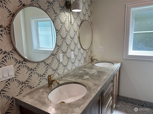 bathroom featuring oversized vanity, double sink, and a wealth of natural light