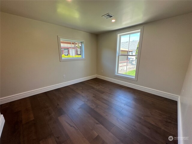 unfurnished room with dark hardwood / wood-style flooring