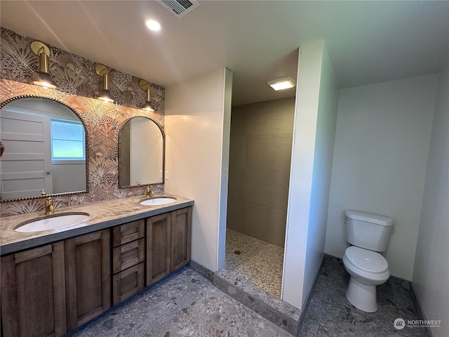 bathroom with walk in shower, tile floors, large vanity, dual sinks, and toilet