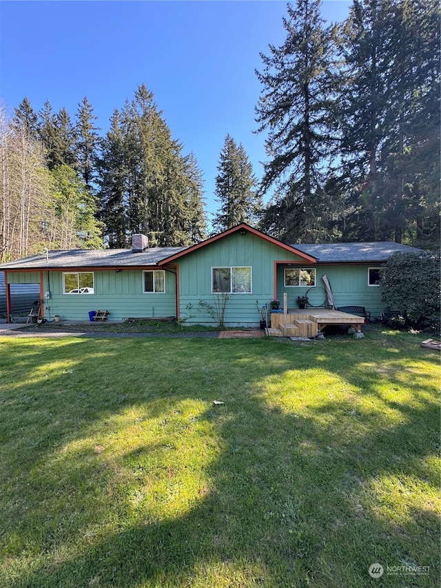 view of front of property with a wooden deck and a front lawn