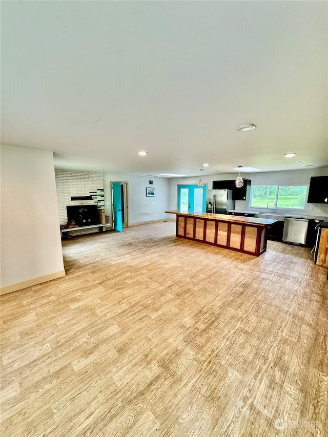 unfurnished living room featuring sink and light wood-type flooring