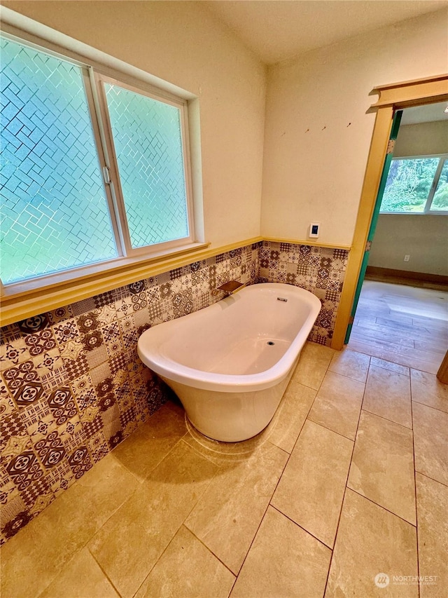 bathroom featuring a bathing tub, tile patterned flooring, and tile walls