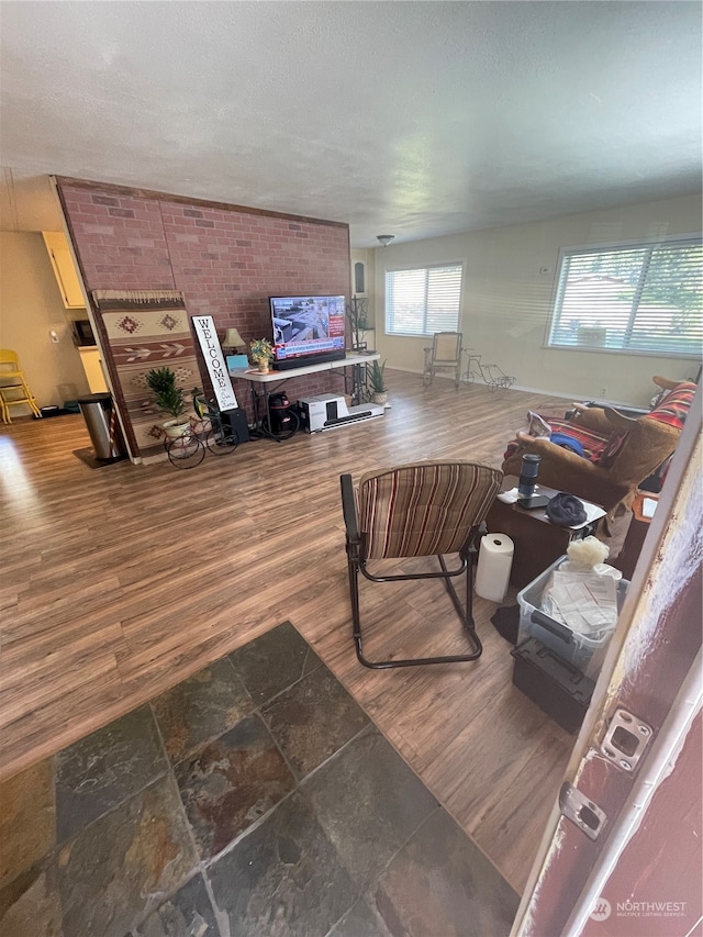 living room with wood-type flooring and brick wall