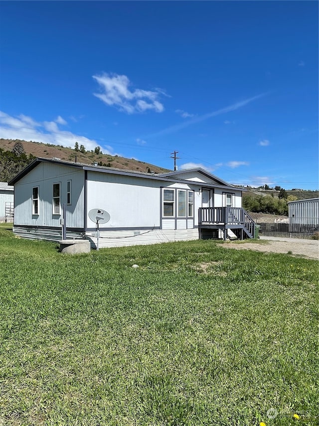 back of house featuring a deck and a yard