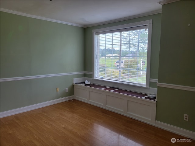 empty room with crown molding and hardwood / wood-style flooring