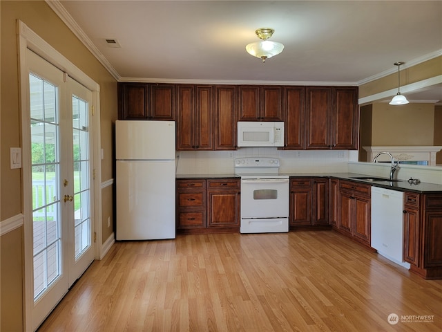 kitchen with light wood-type flooring, white appliances, pendant lighting, sink, and plenty of natural light