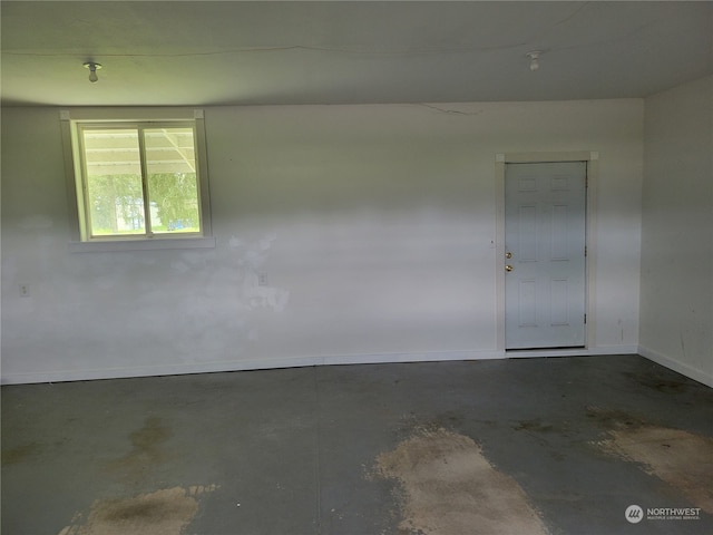 unfurnished room with concrete flooring