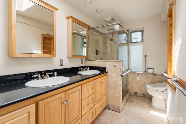 bathroom featuring dual sinks, toilet, tile floors, a shower with shower door, and large vanity