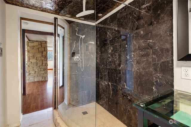 bathroom with wood-type flooring and a tile shower