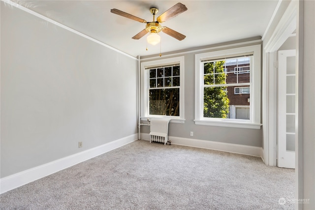 carpeted empty room with ceiling fan and crown molding