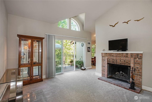 carpeted living room with a brick fireplace and high vaulted ceiling