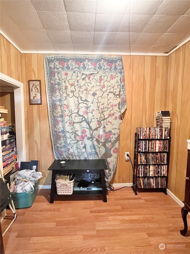 living area with wood walls and hardwood / wood-style flooring