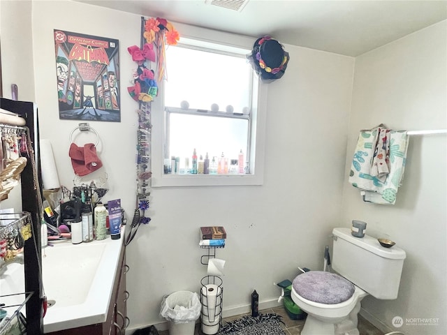 bathroom featuring tile floors, vanity, and toilet