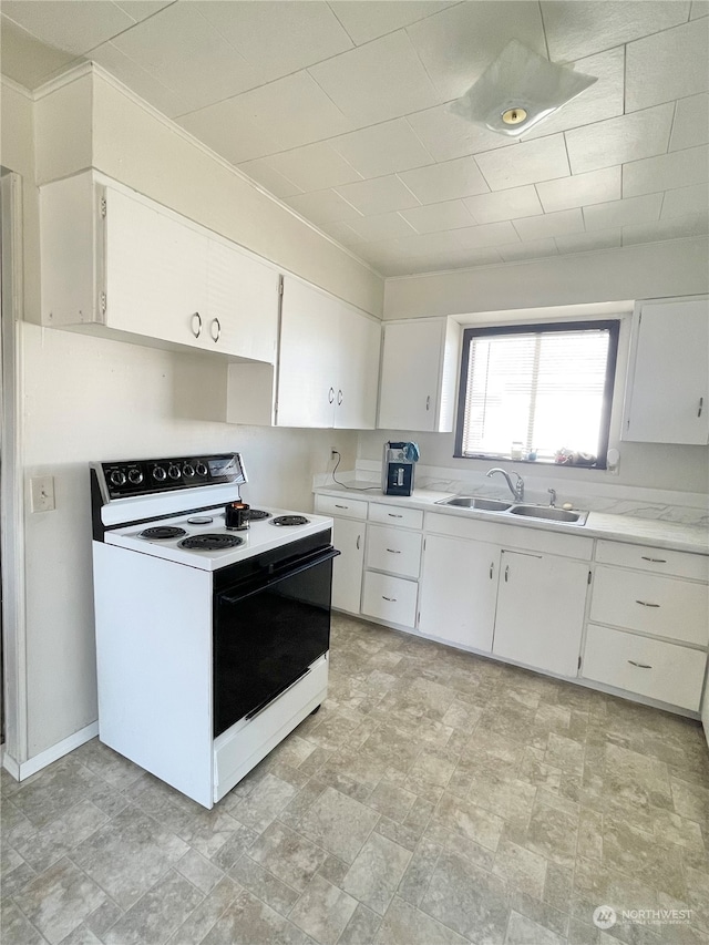 kitchen featuring sink, electric stove, white cabinets, and light tile flooring