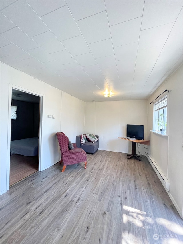 unfurnished room with a baseboard radiator and wood-type flooring