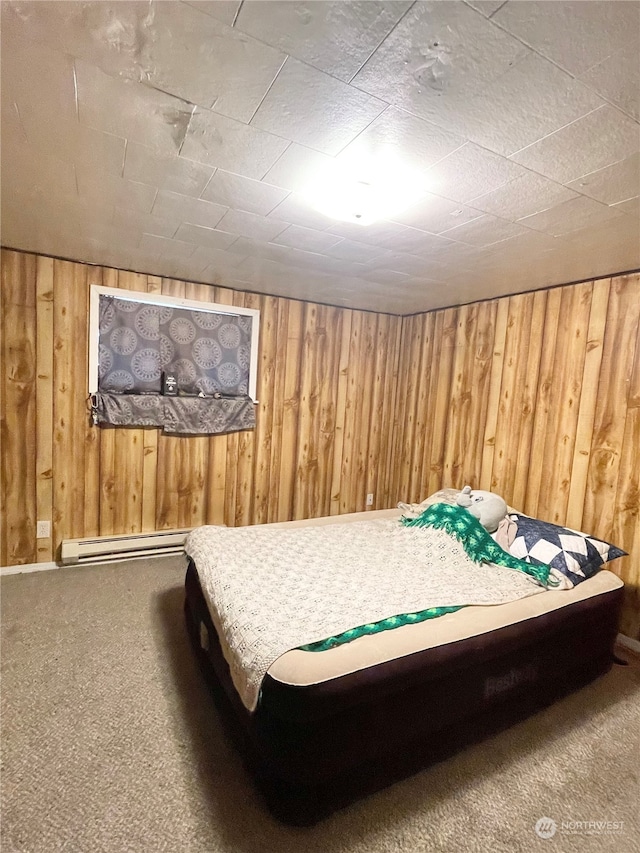 carpeted bedroom with baseboard heating and wooden walls